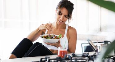 Fit Woman Eating Salad After Pur-Pharma Gym Workout with Smoothie