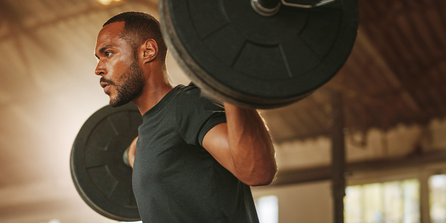 Fit Black Man Squatting with Barbell